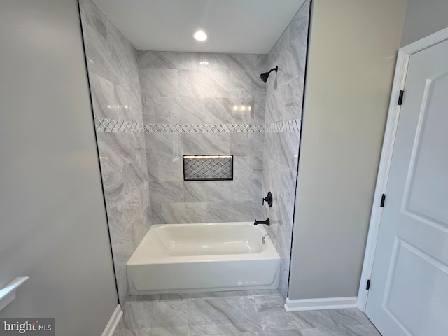 full bath with marble finish floor, bathing tub / shower combination, and baseboards