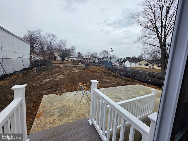 wooden terrace featuring a residential view and fence