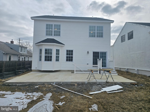 back of property with fence and a patio