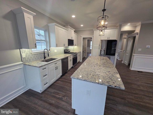 kitchen featuring a sink, white cabinetry, appliances with stainless steel finishes, a center island, and dark wood finished floors