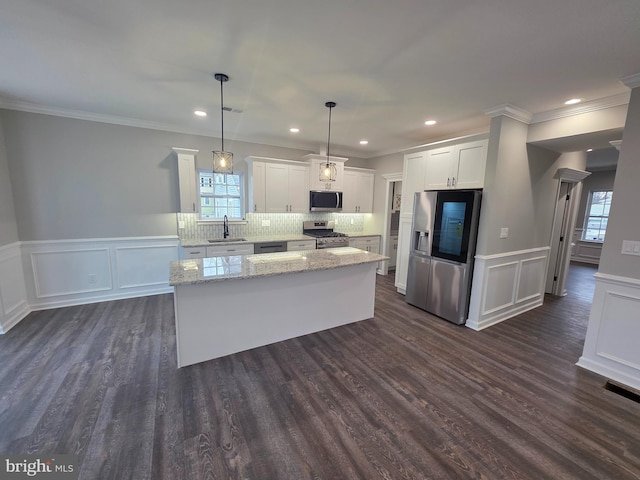 kitchen with a sink, stainless steel appliances, a healthy amount of sunlight, and white cabinets