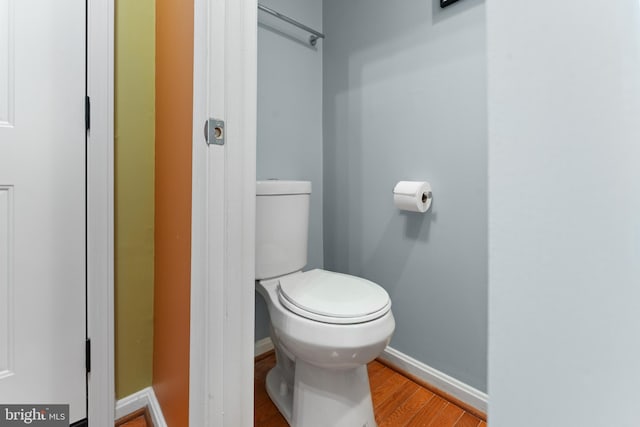 bathroom featuring baseboards, toilet, and wood finished floors