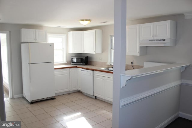 kitchen with white appliances, white cabinets, and light tile patterned floors