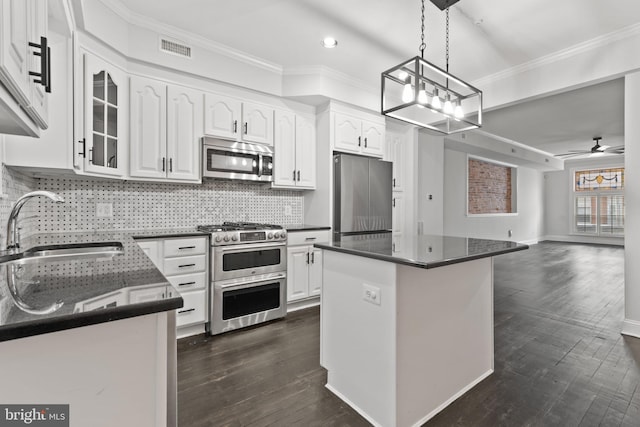 kitchen featuring ceiling fan, white cabinetry, sink, a kitchen island, and appliances with stainless steel finishes