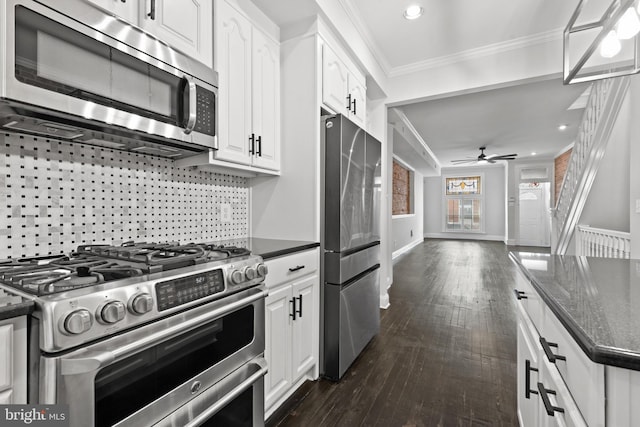 kitchen featuring white cabinetry, ceiling fan, dark wood-type flooring, stainless steel appliances, and crown molding