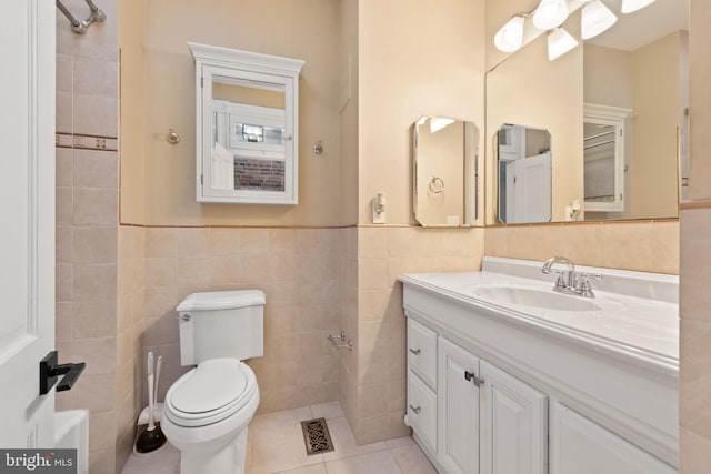 bathroom with tile patterned floors, vanity, toilet, and tile walls