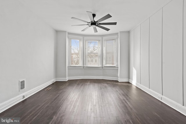 spare room featuring ceiling fan and dark wood-type flooring