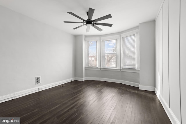 empty room featuring ceiling fan and dark hardwood / wood-style flooring