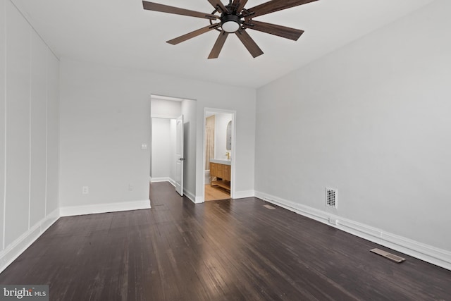 unfurnished bedroom with connected bathroom, ceiling fan, and dark wood-type flooring