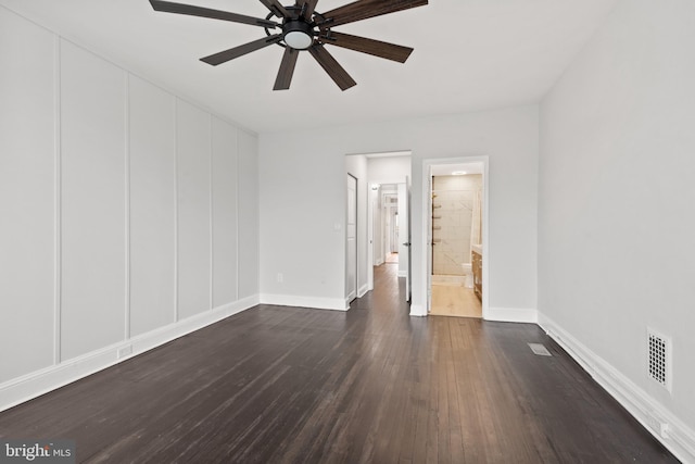 empty room with ceiling fan and dark hardwood / wood-style flooring