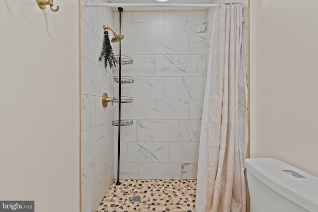 bathroom featuring a shower with shower curtain and toilet