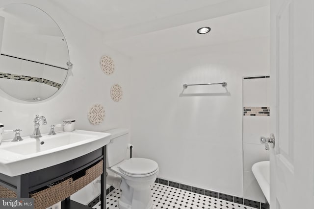 bathroom with sink, a bathtub, and toilet