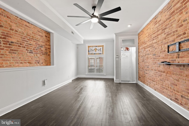 unfurnished room featuring ceiling fan, ornamental molding, dark wood-type flooring, and brick wall