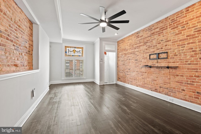 spare room with ceiling fan, brick wall, dark hardwood / wood-style floors, and ornamental molding