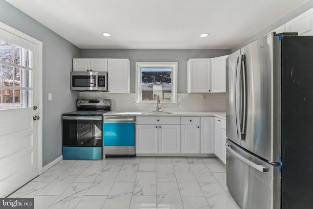 kitchen with stainless steel appliances, sink, and white cabinets