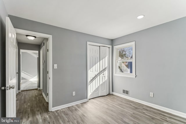 unfurnished bedroom with a closet and light hardwood / wood-style flooring