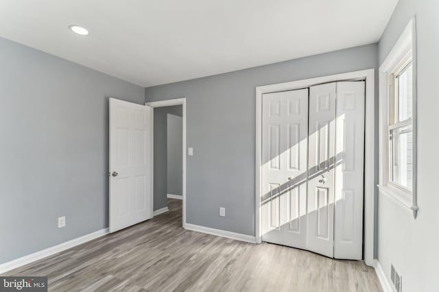 unfurnished bedroom with light hardwood / wood-style floors and a closet