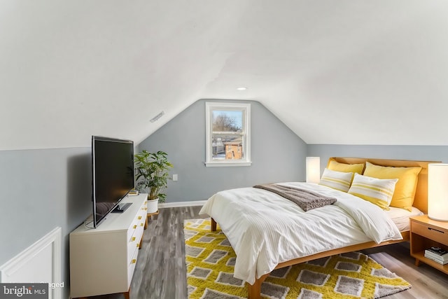 bedroom with lofted ceiling and light hardwood / wood-style flooring