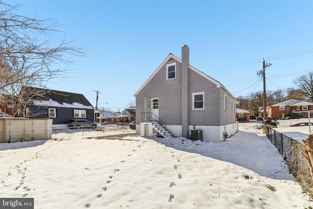 snow covered back of property with cooling unit