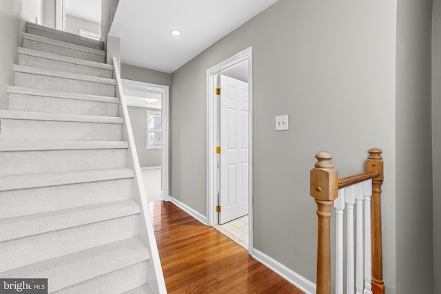 staircase with hardwood / wood-style floors