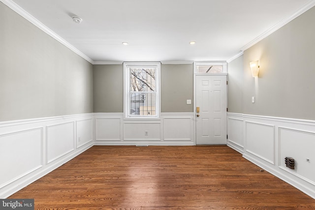 empty room with dark hardwood / wood-style flooring and crown molding