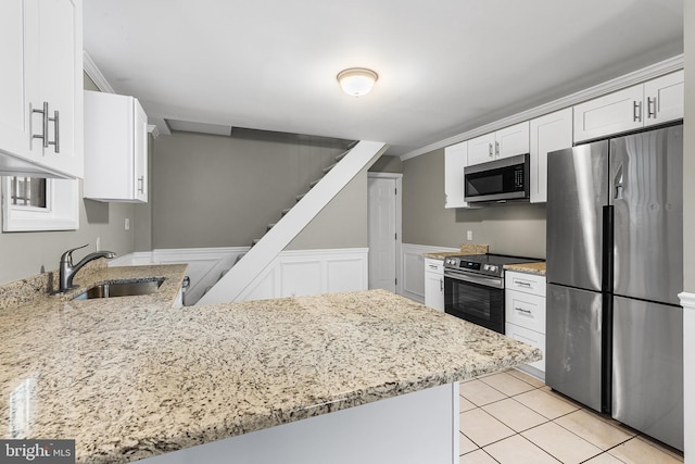 kitchen featuring sink, kitchen peninsula, appliances with stainless steel finishes, and white cabinets