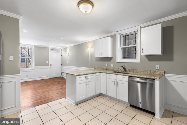 kitchen with light stone counters, stainless steel dishwasher, sink, white cabinetry, and kitchen peninsula