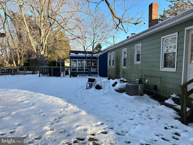 snowy yard featuring central AC