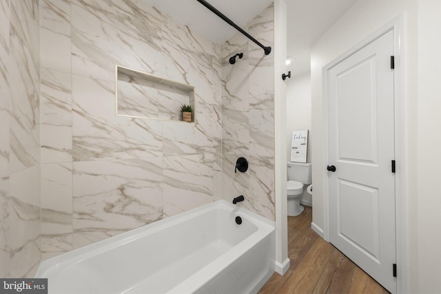 bathroom with tiled shower / bath, toilet, and hardwood / wood-style flooring