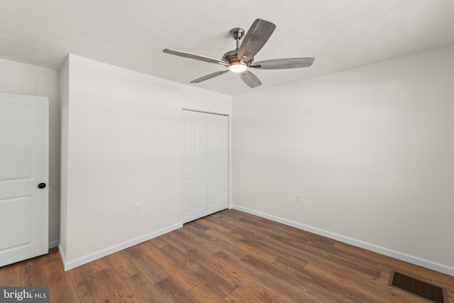 unfurnished bedroom featuring ceiling fan, a closet, and dark hardwood / wood-style floors