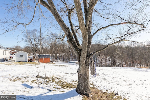 yard layered in snow with a storage shed