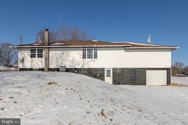 snow covered property featuring a garage