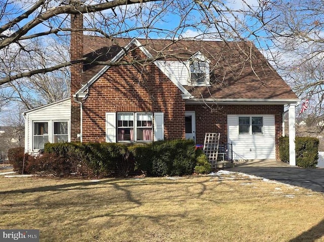 cape cod house featuring a front lawn and a garage