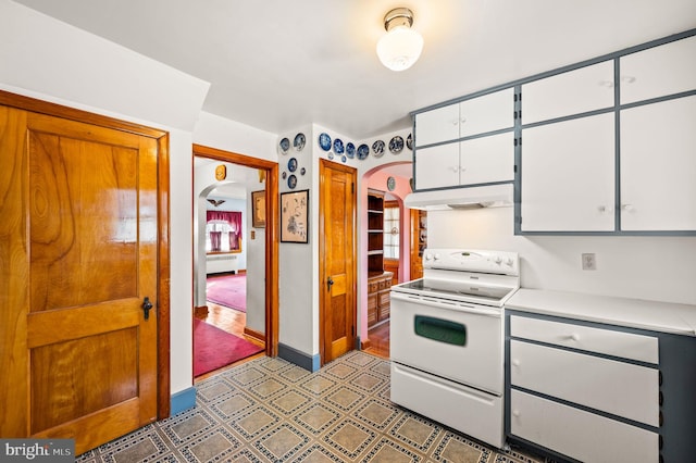 kitchen featuring electric range, radiator heating unit, and white cabinetry