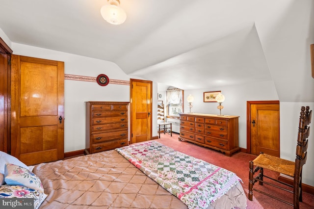 carpeted bedroom with lofted ceiling