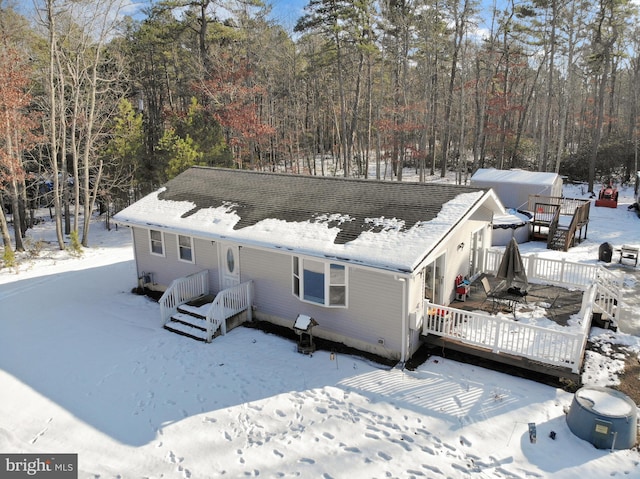 snow covered house with a deck