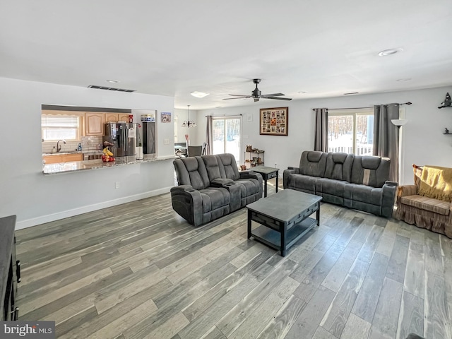 living room featuring hardwood / wood-style flooring, ceiling fan, and sink