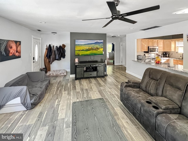 living room with light hardwood / wood-style flooring and ceiling fan