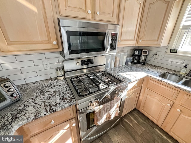 kitchen featuring light brown cabinets, sink, tasteful backsplash, dark hardwood / wood-style flooring, and stainless steel appliances