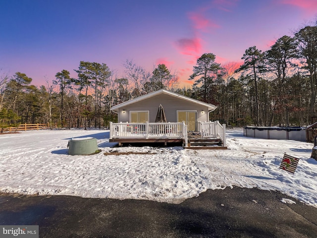 snow covered property with a swimming pool side deck