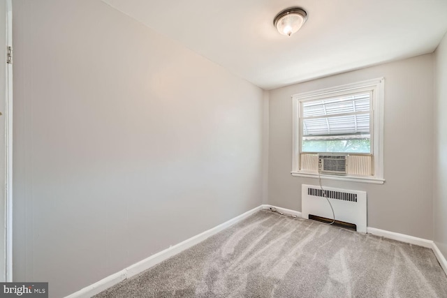 spare room featuring carpet flooring, radiator heating unit, and cooling unit