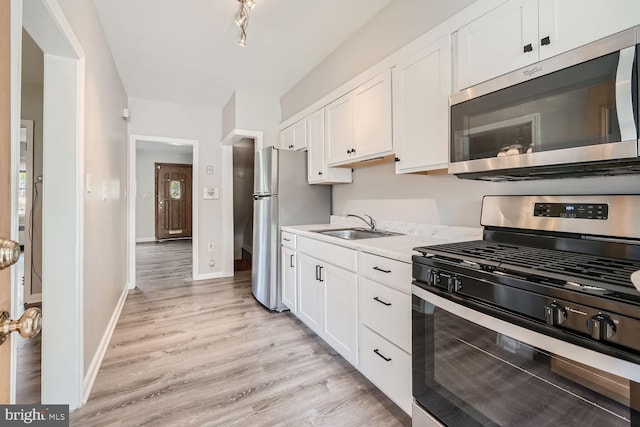 kitchen featuring white cabinets, light hardwood / wood-style floors, sink, and stainless steel appliances