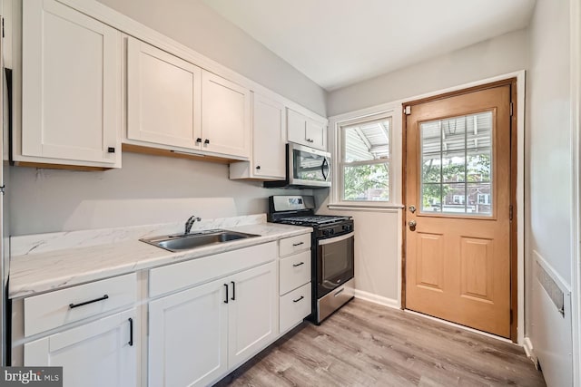 kitchen with sink, white cabinetry, and stainless steel appliances