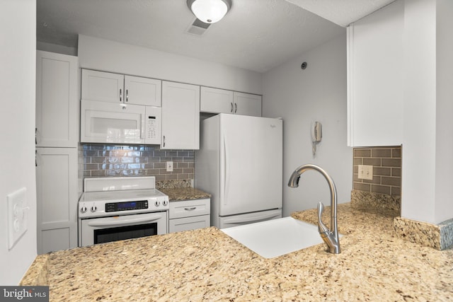 kitchen featuring white appliances, white cabinets, backsplash, and sink