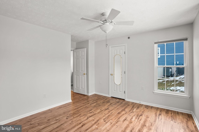 interior space with a textured ceiling, ceiling fan, and light hardwood / wood-style flooring