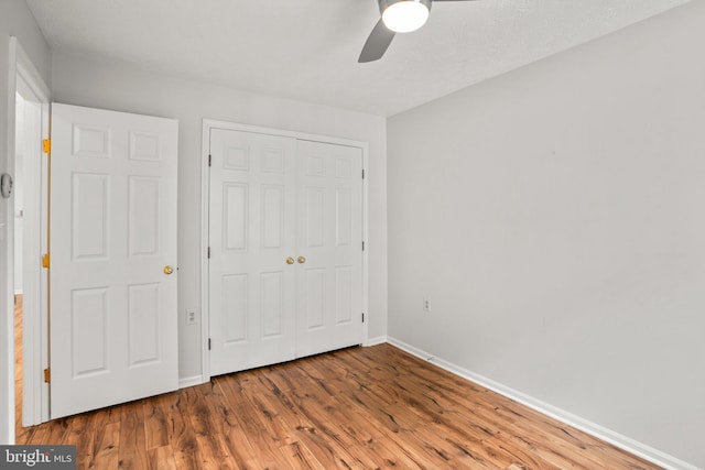 unfurnished bedroom featuring a closet, ceiling fan, and wood-type flooring