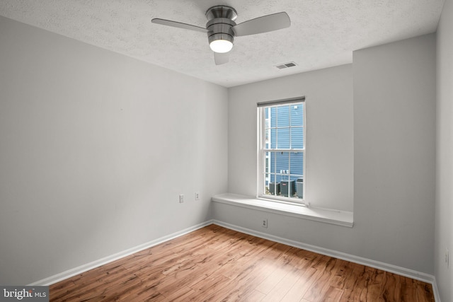 unfurnished room featuring a textured ceiling, ceiling fan, light hardwood / wood-style floors, and a wealth of natural light