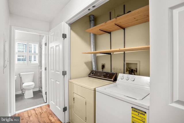 clothes washing area with light hardwood / wood-style floors and separate washer and dryer