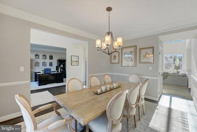 dining space with dark hardwood / wood-style flooring, crown molding, and a notable chandelier