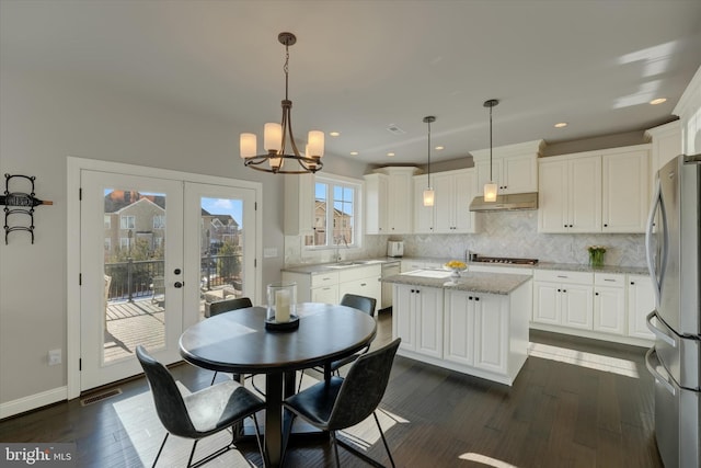 dining area with an inviting chandelier, dark hardwood / wood-style flooring, french doors, and sink